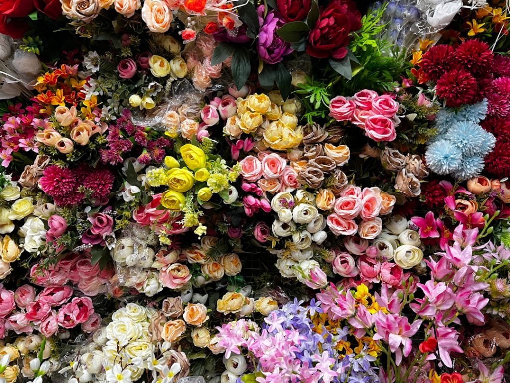 a-bunch-of-flowers-that-are-on-a-wall-dmptnz6tgao Multicoloured different artificial flowers displayed for sell